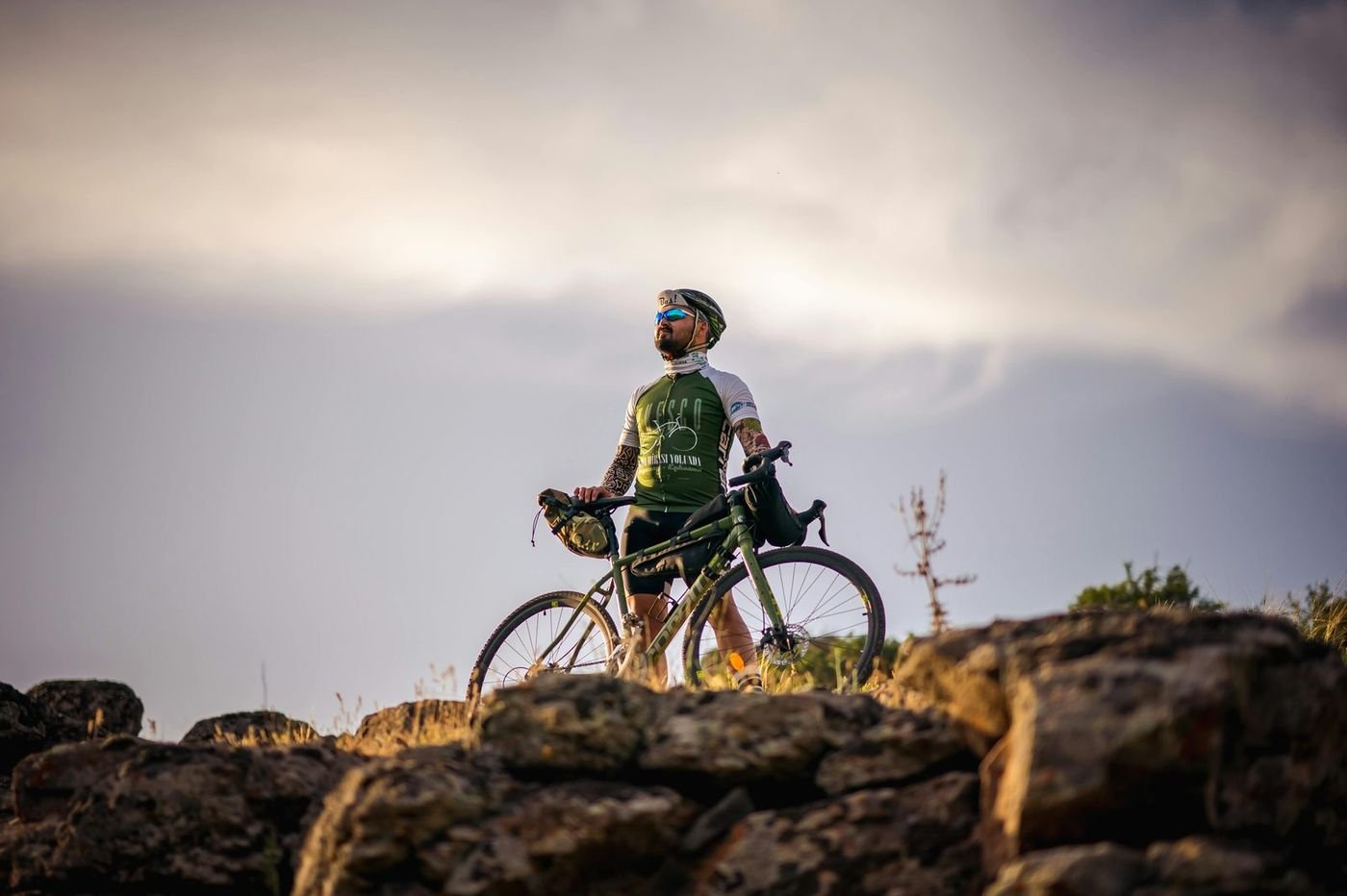 Cyclist at a mountain summit at sunrise, representing vitality and healthy aging